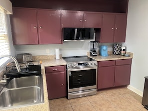 A kitchen with stainless steel appliances, a microwave, a coffee maker, and a toaster. - 2br Albany Oasis (Albany)