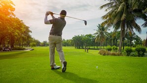 A golfer on a lush green golf course with palm trees and a clear sky. - 11B Jaco Sol Quadplex - Luxury apartment near the beach and commerce (Jacó)