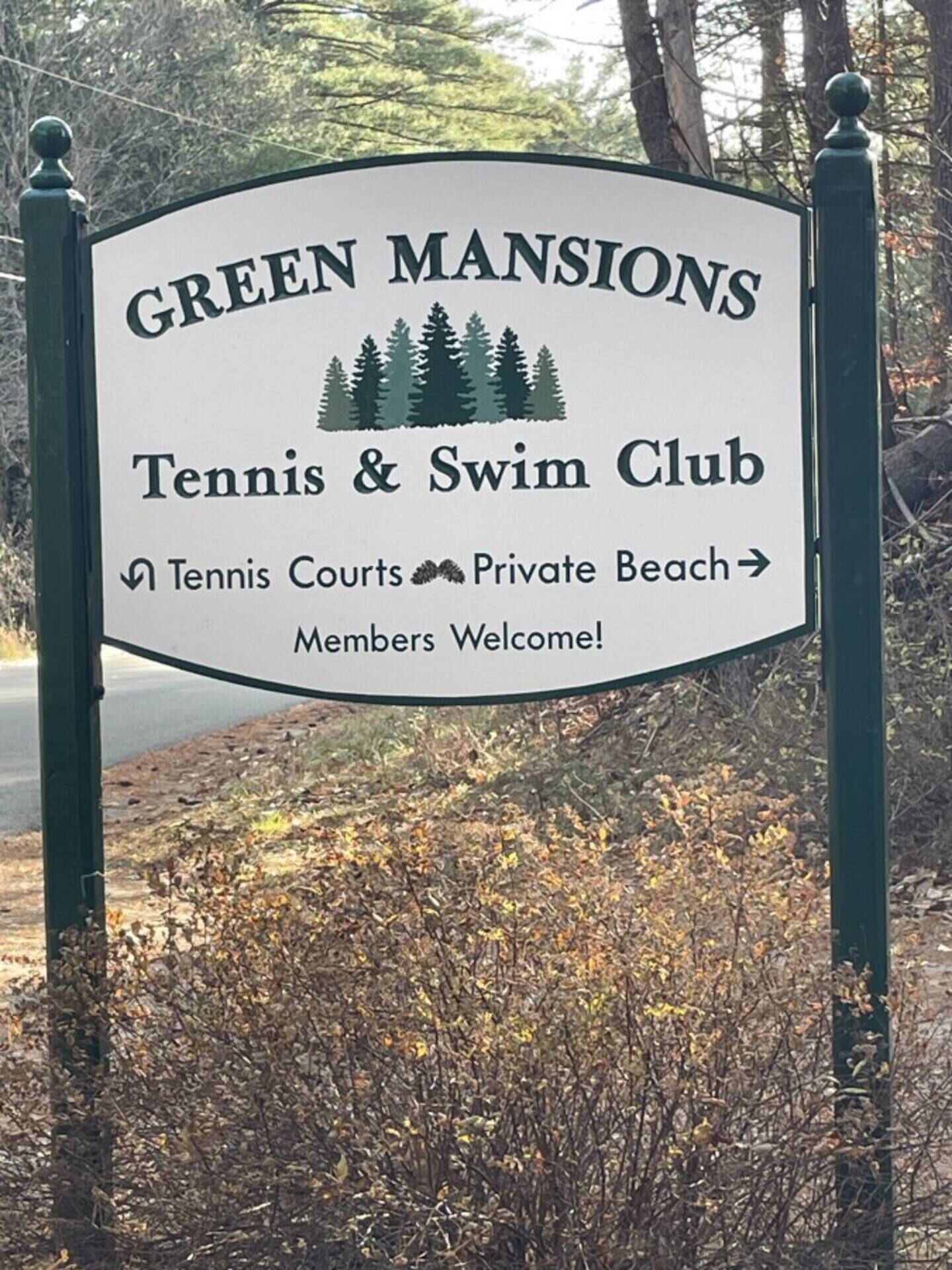 A sign for Green Mansions Tennis & Swim Club with directions to Tennis Courts and Private Beach.