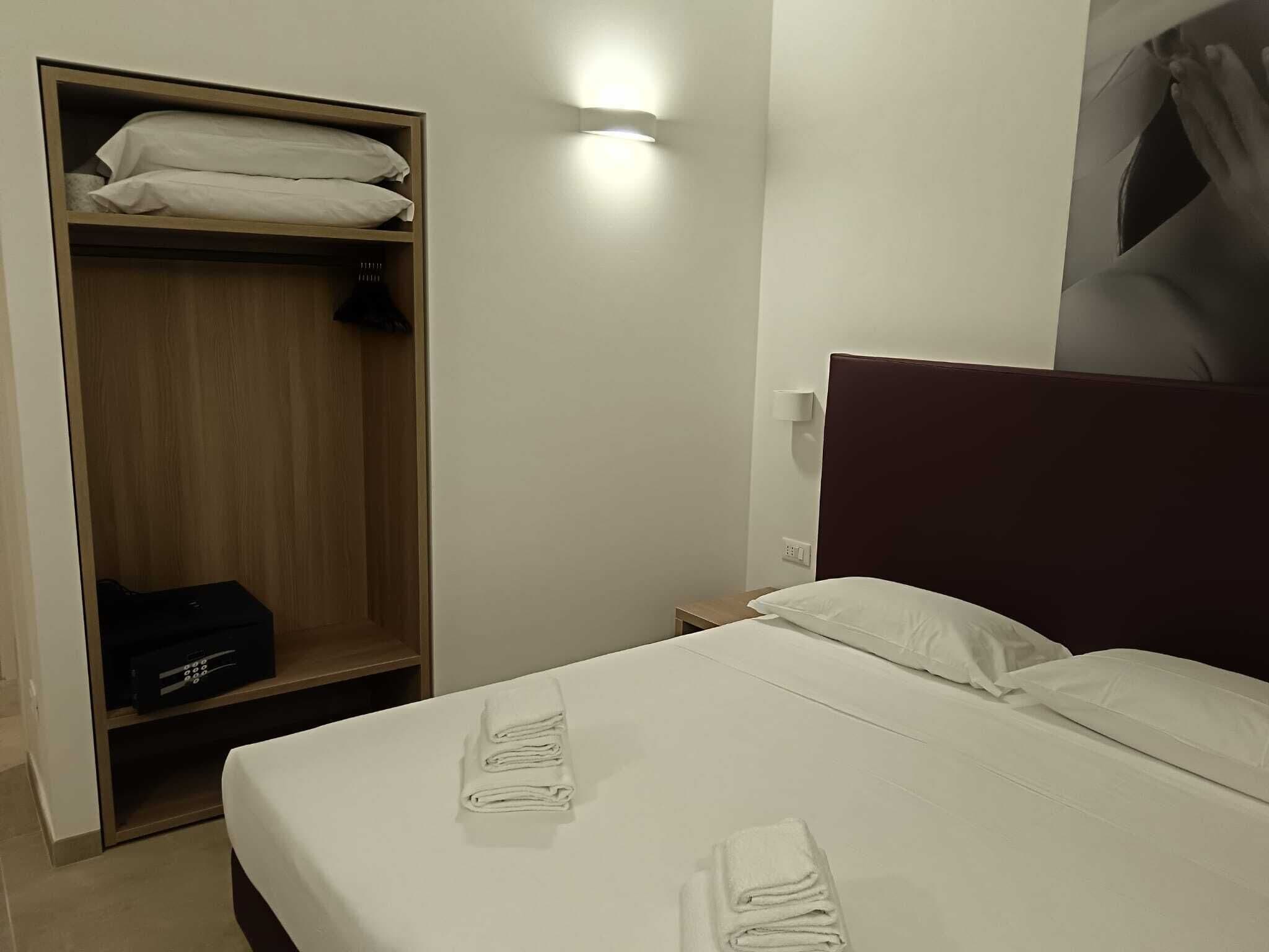 Une chambre d’hôtel avec un lit, une armoire et une table de chevet.