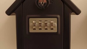 A black house-shaped object with a keyhole and four numbered keys. - Bertiera Rooms (Bologna)