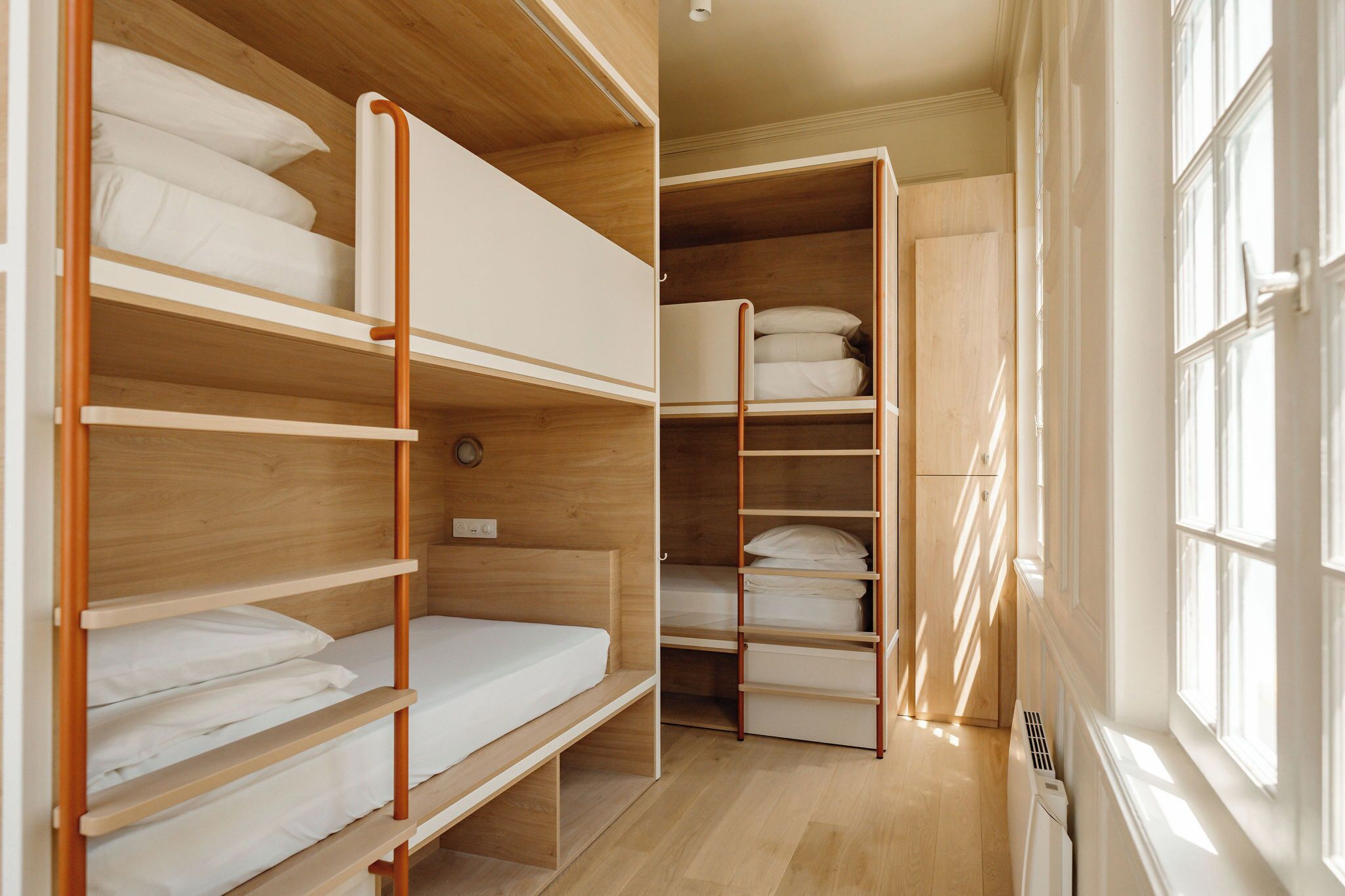 Ein Zimmer mit Etagenbetten, einem Kleiderschrank und einer Heizung.