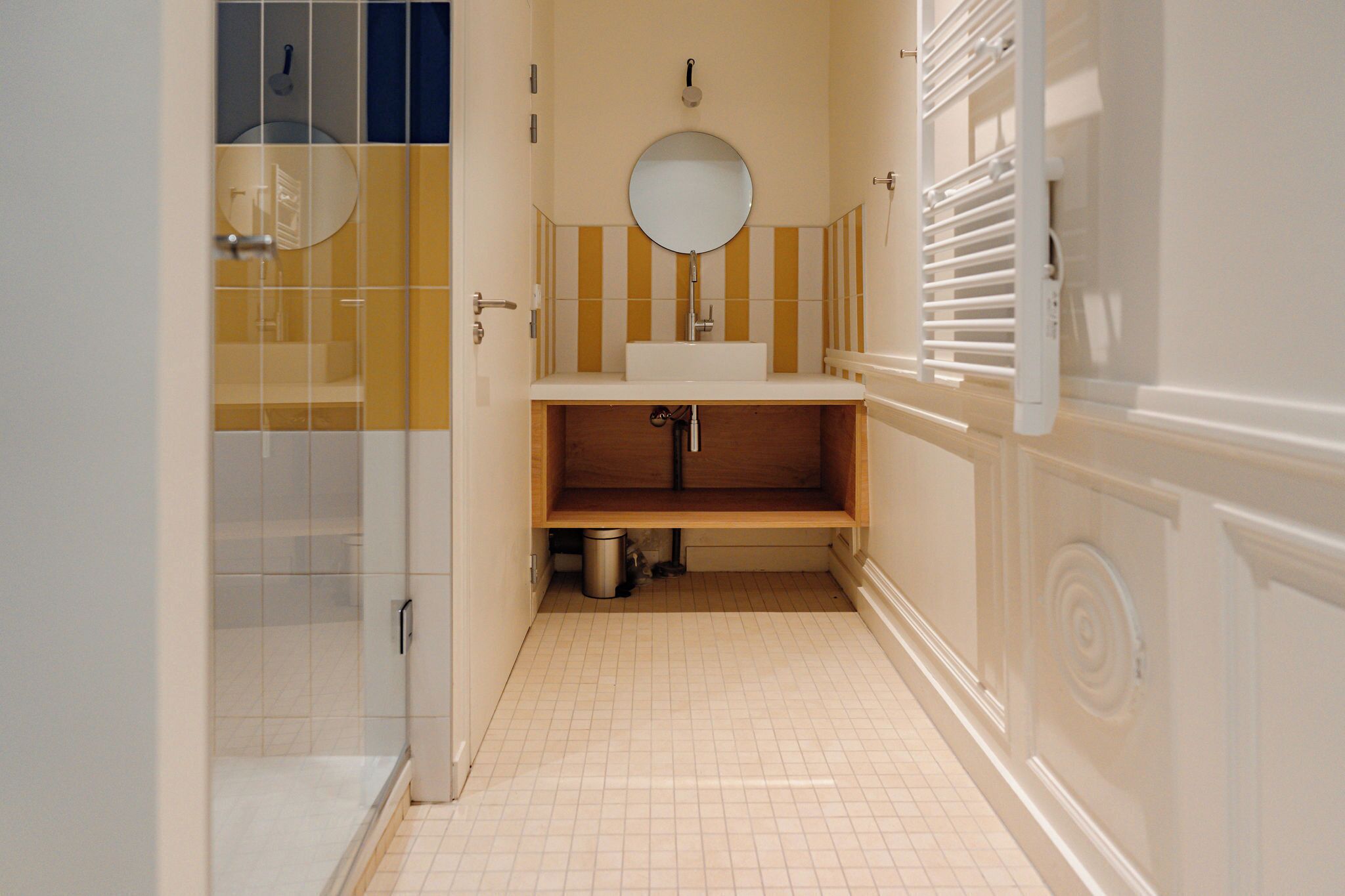 Un bagno con doccia, lavandino e specchio.