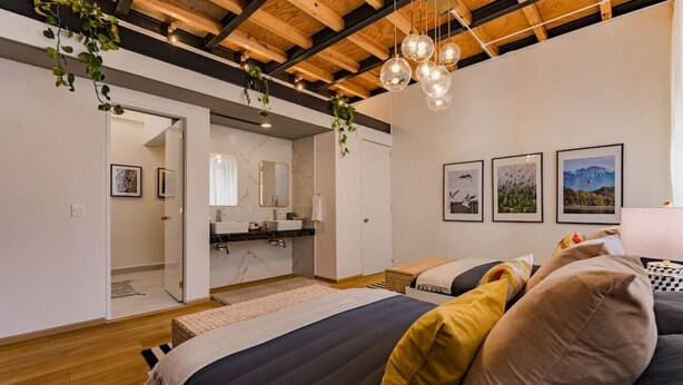 A modern bedroom with a bed, a bathroom, and a living area. - Majestic Heights: Retreat in La Condesa (Ciudad de México)