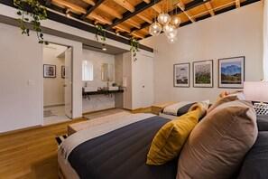 Un dormitorio moderno con cama, baño y sala de estar.