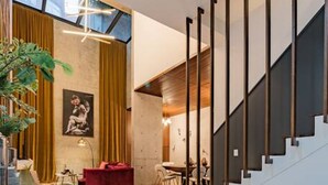 A spacious living area with a staircase, a dining area, and a red sofa. - Majestic Heights: Retreat in La Condesa (Ciudad de México)