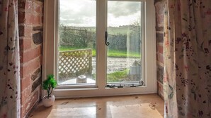 A stone-framed window with a wooden ledge and a potted plant. - Elegant and Secluded 1-bed Cottage Near Bideford (Bideford)