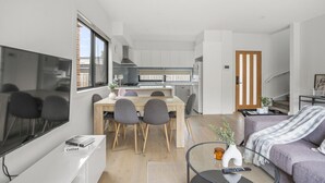 A modern apartment with a dining area, kitchen, and living space. - StayAU Modern 4BRM TH Bayswater (Bayswater North)