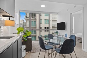 A modern apartment with a dining area, kitchen, and a balcony with a city view. - Downtown Miami 1BR with City Views (Miami)