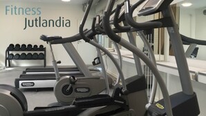 Un gimnasio con cintas de correr y mancuernas.