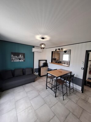A compact living space with a kitchenette, a dining area, and a sofa. - Eco-Logis, house with private garden and terrace0 (Mondeville)