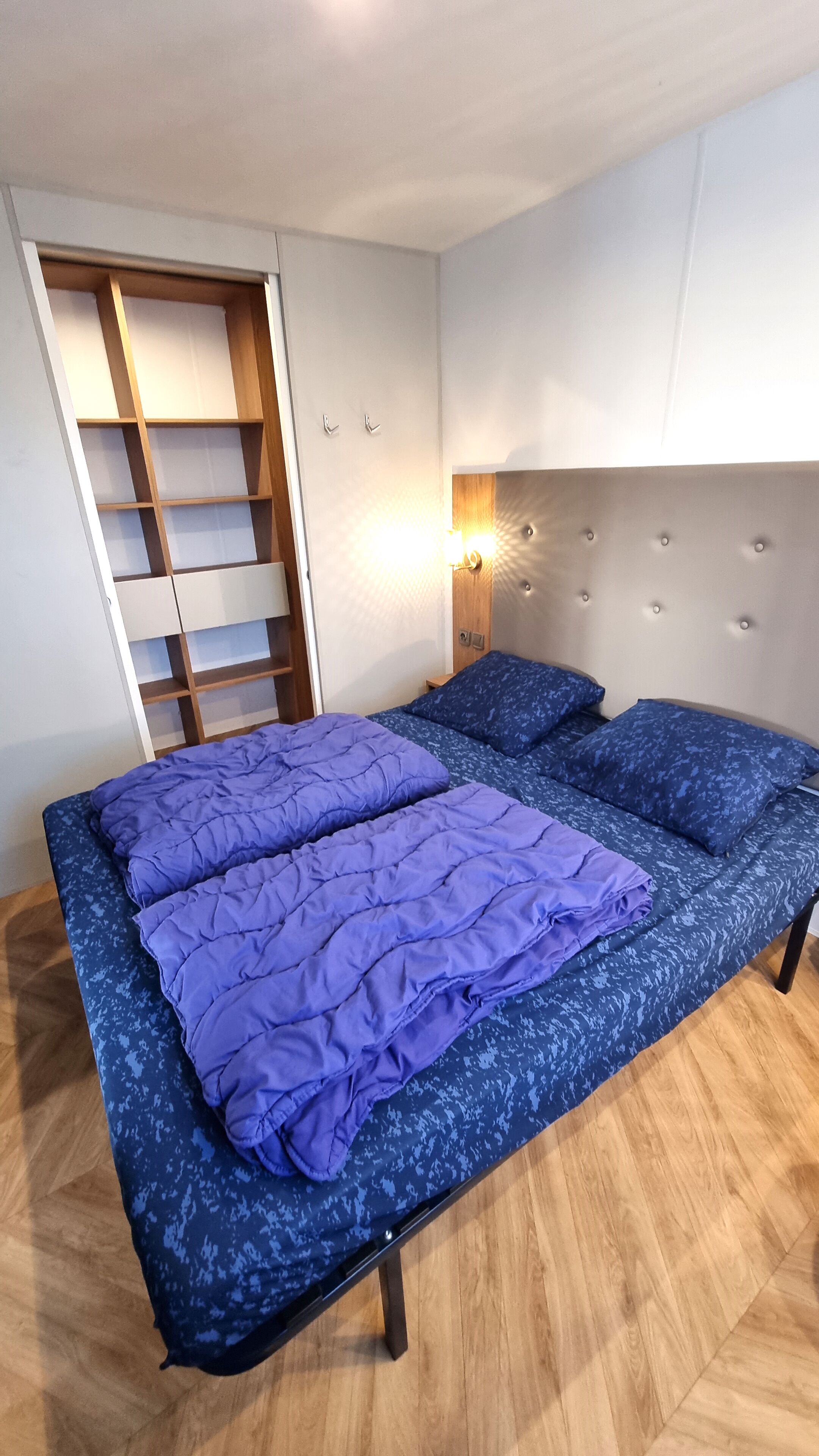 Ein Schlafzimmer mit Bett, Kleiderschrank und Nachttisch.