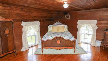 A wooden-paneled room with a bed, a dresser, and a window.