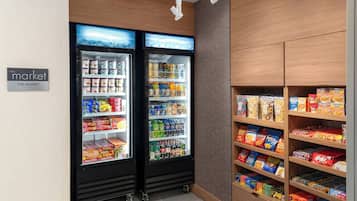 Ein Automatenbereich mit zwei Kühlgeräten, gefüllt mit verschiedenen Snacks und Getränken.