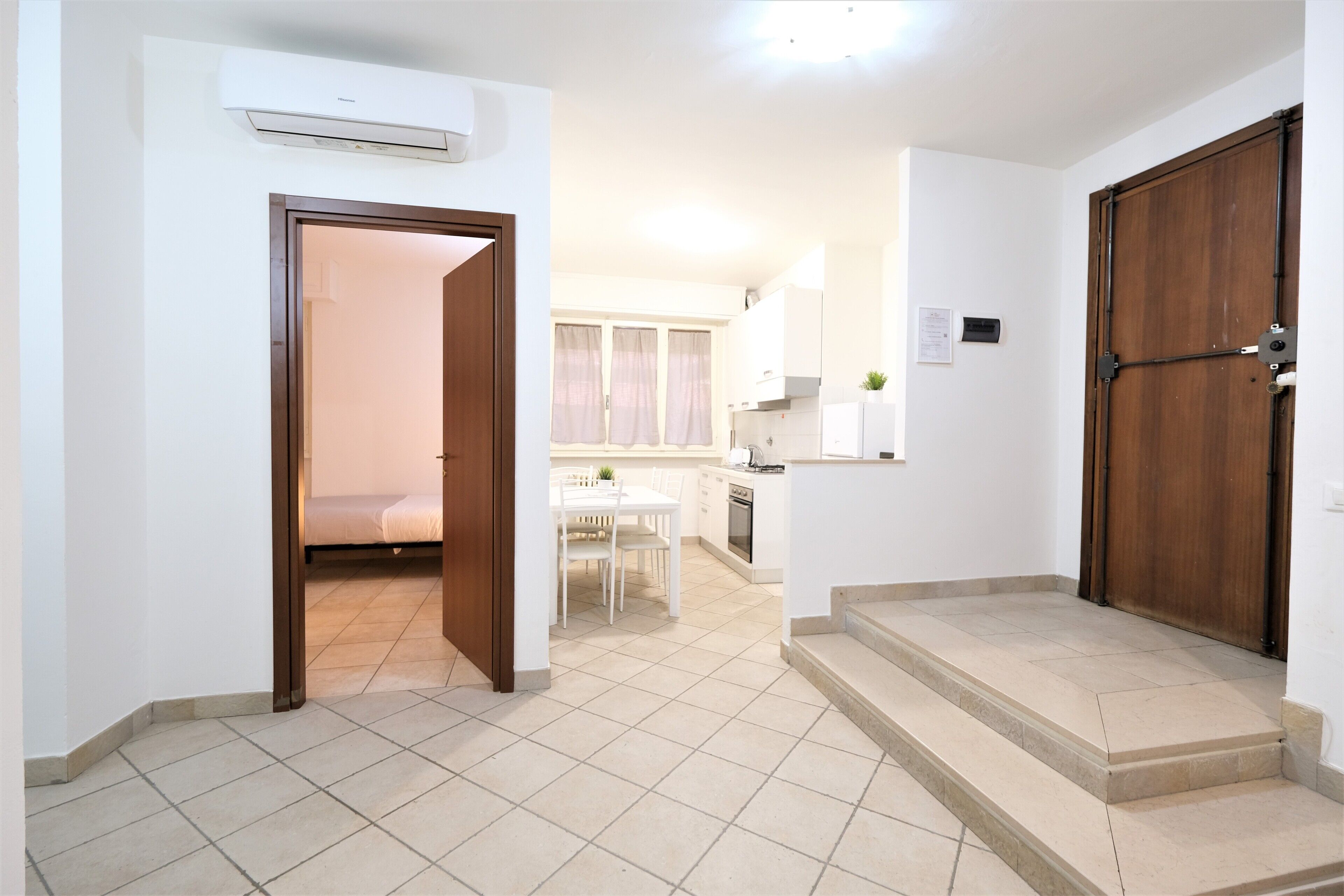 A modern apartment with a kitchen, dining area, and a bedroom.