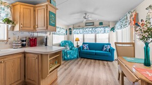 Un espace de vie compact avec des meubles de rangement en bois, un canapé bleu et un coin repas.
