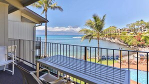 A balcony with a view of the ocean, a pool, and lounge chairs. - Snorkel with sea turtles! Ocean Front & Pool! (Lahaina)
