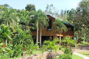 A wooden house surrounded by lush tropical vegetation. - Natural Drake Bay Hotel Boutique (Drake Bay)