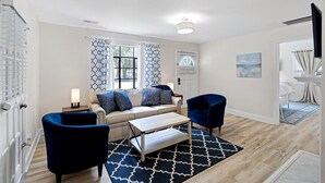 A modern living room with a sofa, two armchairs, a coffee table, and patterned curtains. - Noda Home w Yard Perfect For Digital Nomads 250 Mbps Fiber! (Charlotte)