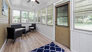 A sunroom with a ceiling fan, large windows, and a door with blinds. - Noda Home w Yard Perfect For Digital Nomads 250 Mbps Fiber! (Charlotte)