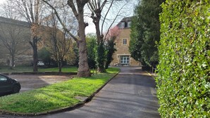 A residential street with a manhole cover, a hedge, and a building with a window. - Château des Princes " Fleur de Lys " (Sedan)