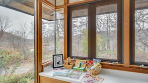 A bay window with a view of a forested area. - Historic Wisconsin Retreat on 26-Acre Property! (Plain)