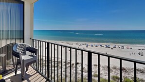 Un balcon avec vue sur une plage et l’océan.
