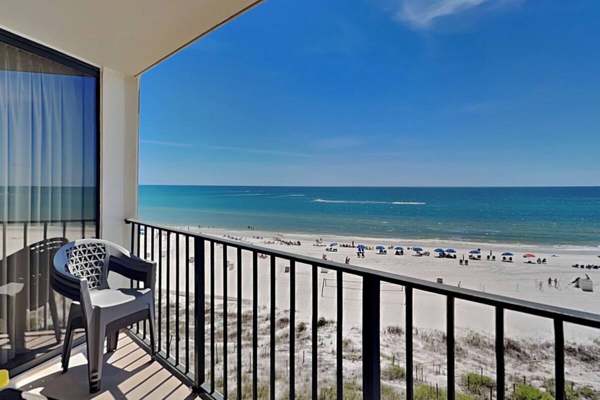 Un balcon avec vue sur une plage et l’océan.