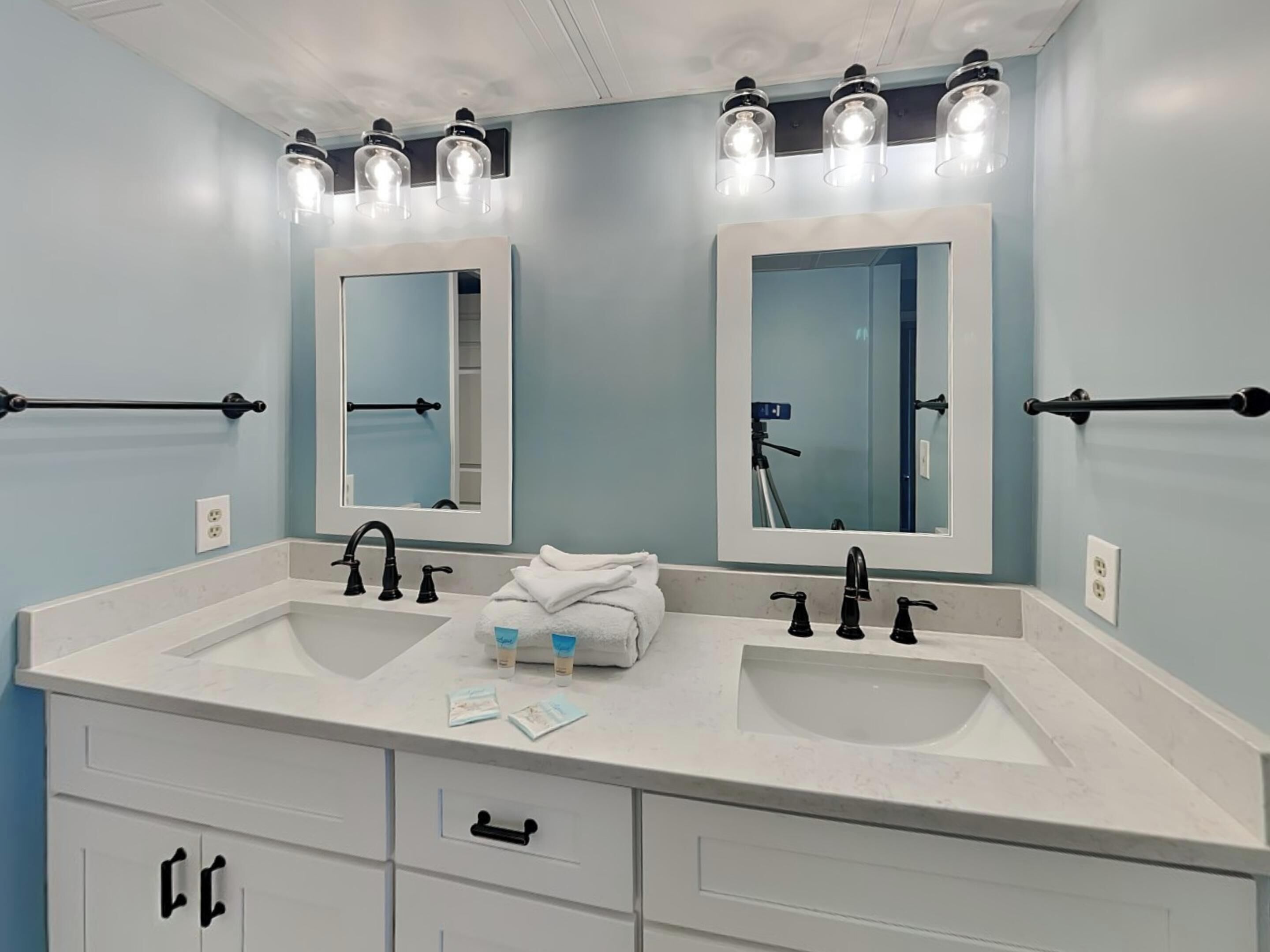 Une salle de bain avec deux lavabos, un miroir et un porte-serviettes.