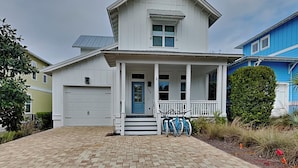 Een herenhuis met een voortuin, een garage en een verzorgd gazon.