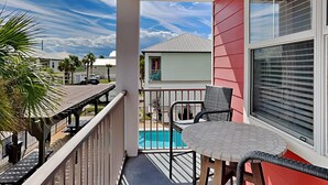A balcony with a pool, outdoor furniture, and a view of neighboring houses. - Runnin Down A Dream by Southern Vacation Rentals (Miramar Beach)