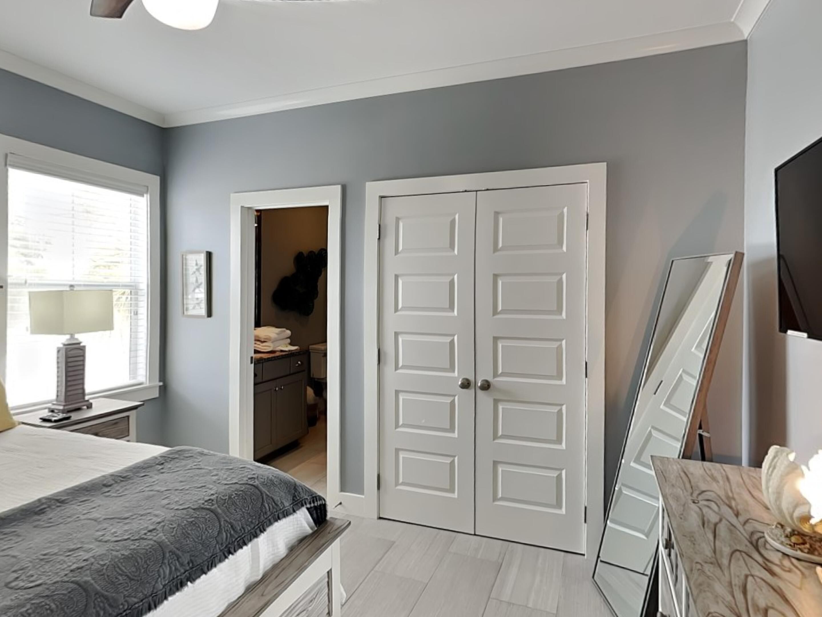 A bedroom with a bed, a dresser, a mirror, and a closet.