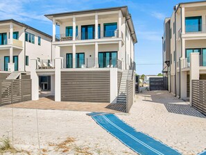 A modern multi-story residential building with a covered outdoor area and a pool. - Viviana #8 by Southern Vacation Rentals (Pensacola)