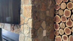 A stone wall with a flat-screen TV mounted on it. - 1. Apartment with hot tub and fireplace (Rockaway Beach)