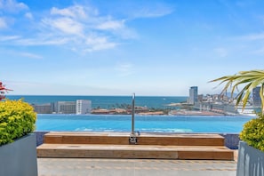 A poolside area with a view of the ocean and city skyline. - MONYXBNB HOTEL (Puerto Vallarta)