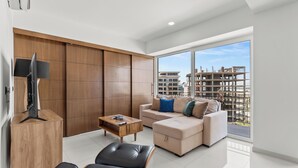 A modern living room with a sofa, a coffee table, and a TV stand. - MONYXBNB HOTEL (Puerto Vallarta)