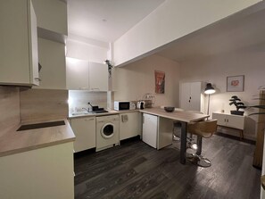 Enjoy a functional and contemporary living space with a modern kitchen, dining area, and cozy seating area.