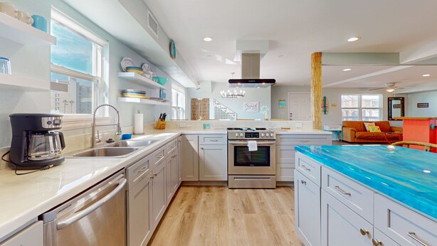 A modern kitchen with stainless steel appliances, a dishwasher, and a blue countertop. - Wet Bar, Outdoor Games, Gulf Views, Pet Friendly (Port Aransas)