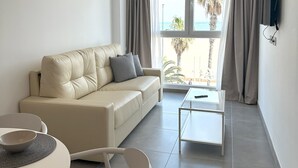 Una sala de estar moderna con sofá, mesa de centro y comedor.