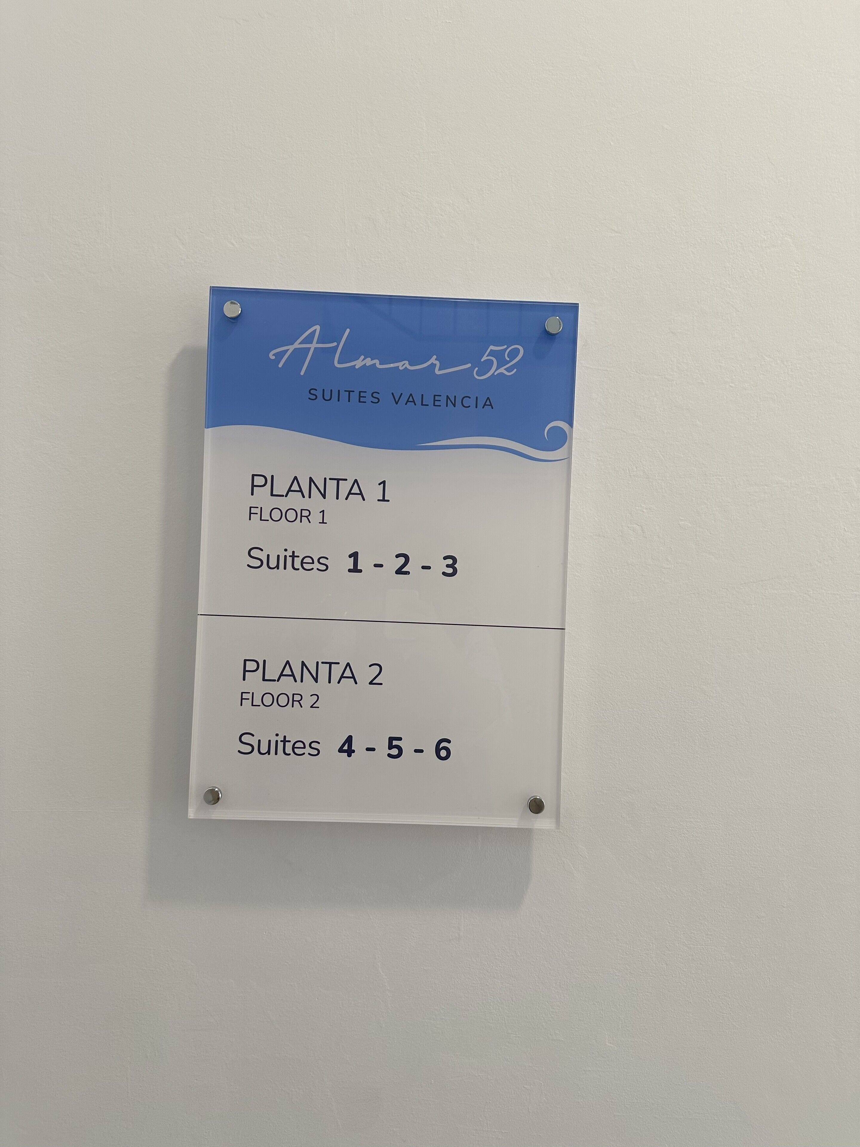 Une enseigne indiquant « Almar 52 Suites Valencia » avec les mentions « PLANTA 1, ÉTAGE 1, Suites 1-2-3 » et « PLANTA 2, ÉTAGE 2, Suites 4-5-6 ».