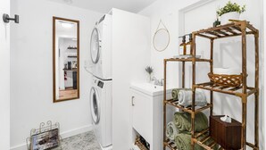 A laundry area with a washing machine, a drying rack, and a mirror. - Cozy Guest Suite in West Highlands (Denver)