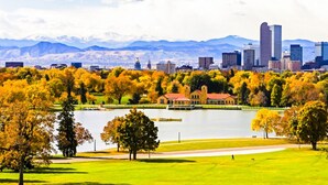 A cityscape with a lake, autumn trees, and mountains in the background. - Cozy Guest Suite in West Highlands (Denver)