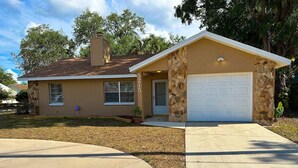 A single-story house with a stone facade, a garage, and a front yard.