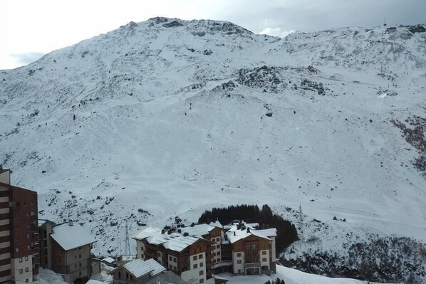 A snow-covered mountain with a lodge featuring multiple buildings and a ski lift.