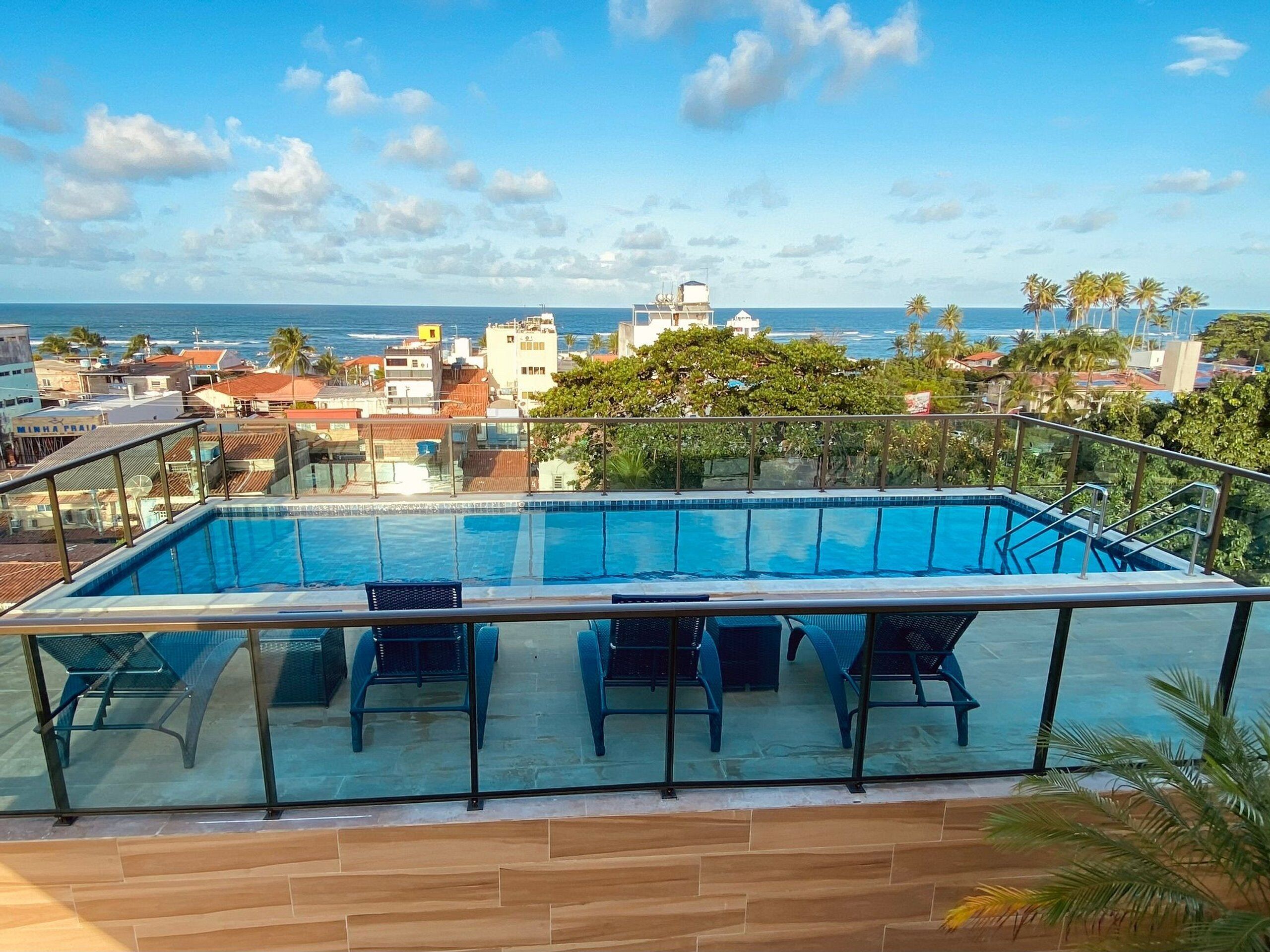 A rooftop pool with clear views of the ocean and cityscape.