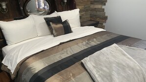 A bed with a striped bedspread, two pillows, and a blanket. - 2. Apartment with Lake View (Rockaway Beach)