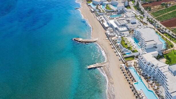 An aerial view of a coastal hotel with a long poolside, beachfront, and multiple buildings. - Kalimera apartment 5 ,Near beach and all amenities (Adelianos Kampos)