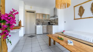 A compact kitchen with white cabinets, a wooden countertop, and a hanging light fixture. - Kalimera apartment 5 ,Near beach and all amenities (Adelianos Kampos)