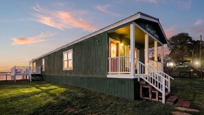 A wooden building with a porch and a staircase, labeled 'Sunset Cove.' - Lake Front Lake House Paradise! (Pittsburg)