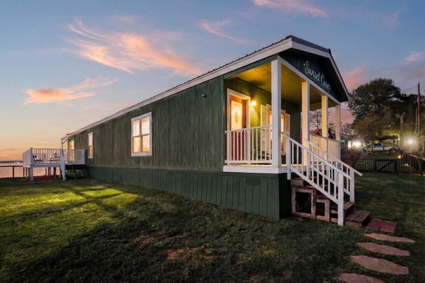 Lakefront cabin exterior with porch at sunset